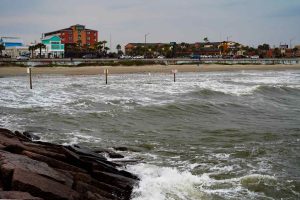 View from the Gulf of Mexico of the beach, seawall, restaurants and hotels on the Strand, Galveston, Texas, USA